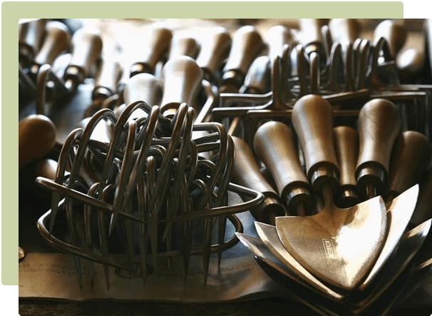 Hand forged Sneeboer garden tools laid out on a wooden bench