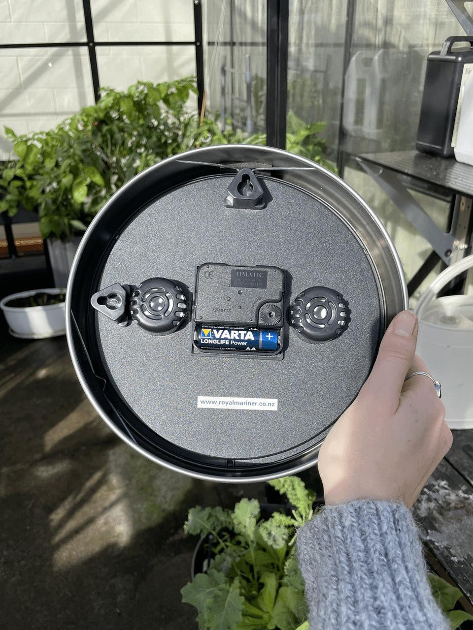 White Gardening by the Moon Clock by Cruising Electronics, featuring a round face with moon phase indicators and gardening tips.