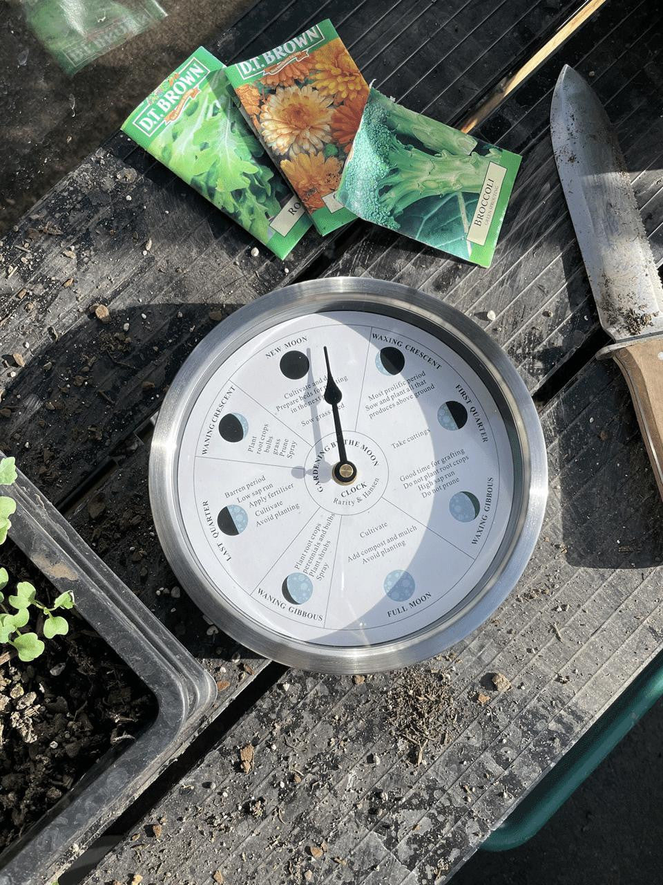 White Gardening by the Moon Clock by Cruising Electronics, showing moon phases and gardening tips on a sleek white face.