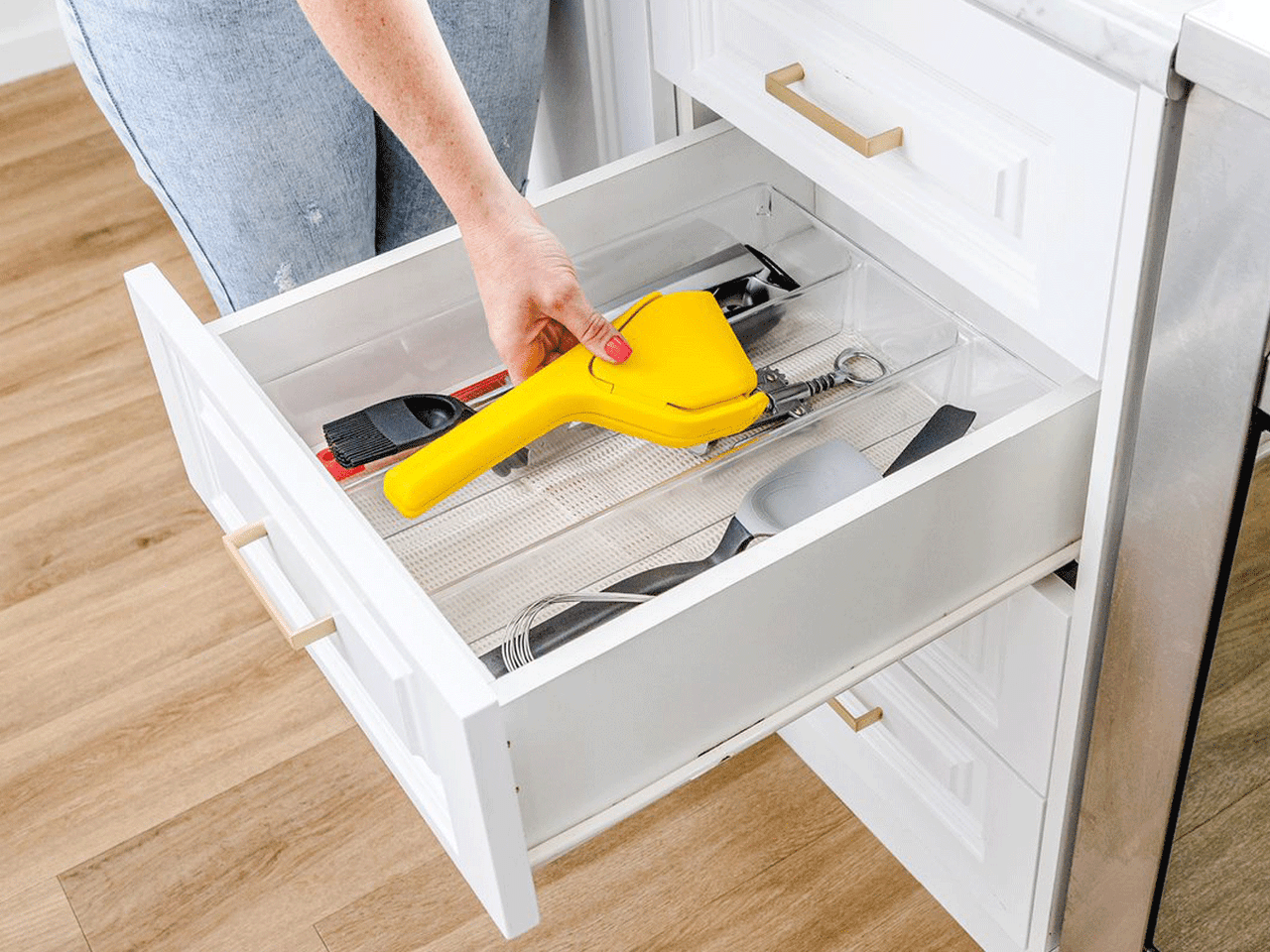 Dreamfarm Fluicer kitchen tool with a sleek design, featuring a handle and functional spout for efficient food drainage.