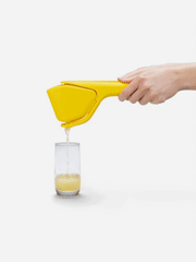 Dreamfarm Fluicer kitchen tool with sleek design, featuring a bright green handle and stainless steel blades for efficient peeling.