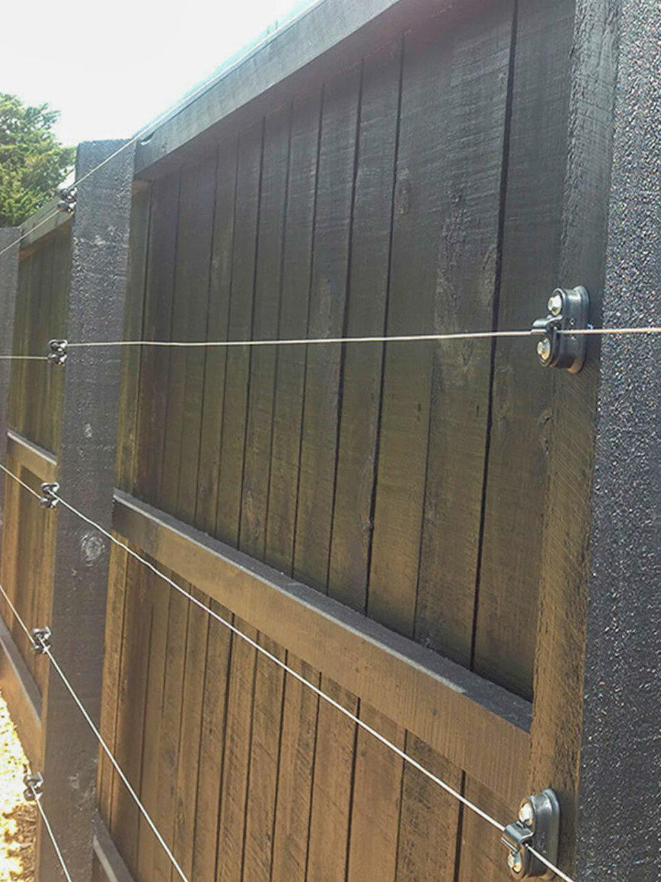 Surface mounted universal espalier kit with wire, by Espalar, featuring mounting hardware for garden or orchard plant training.