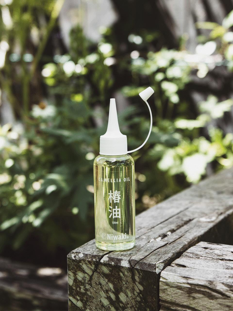 Bottle of Kamaki Camellia Oil with dropper cap, showcasing the natural oil in a clear glass container on a white background.