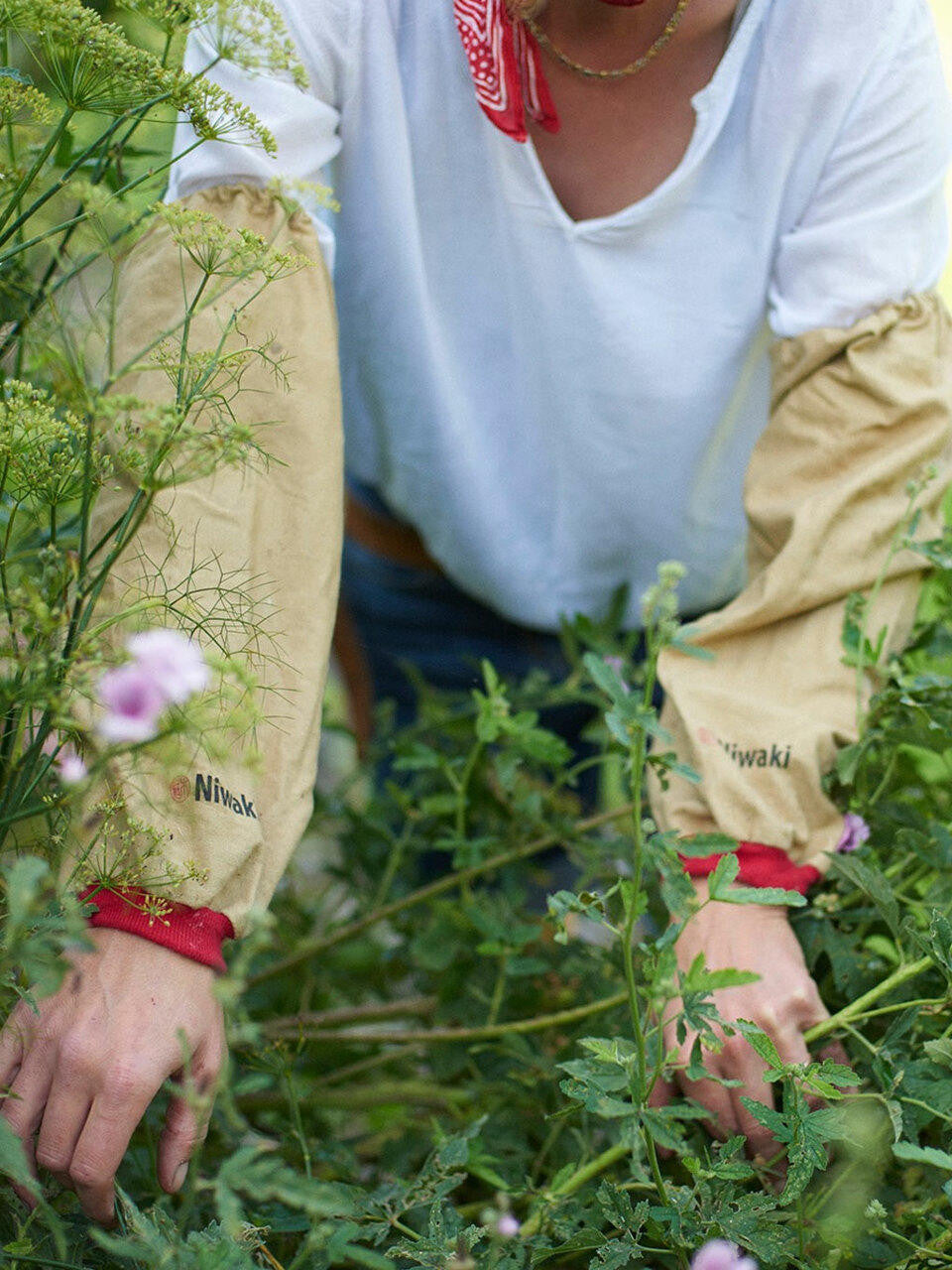 Niwaki arm covers in neutral fabric, designed to protect arms during gardening or outdoor work.