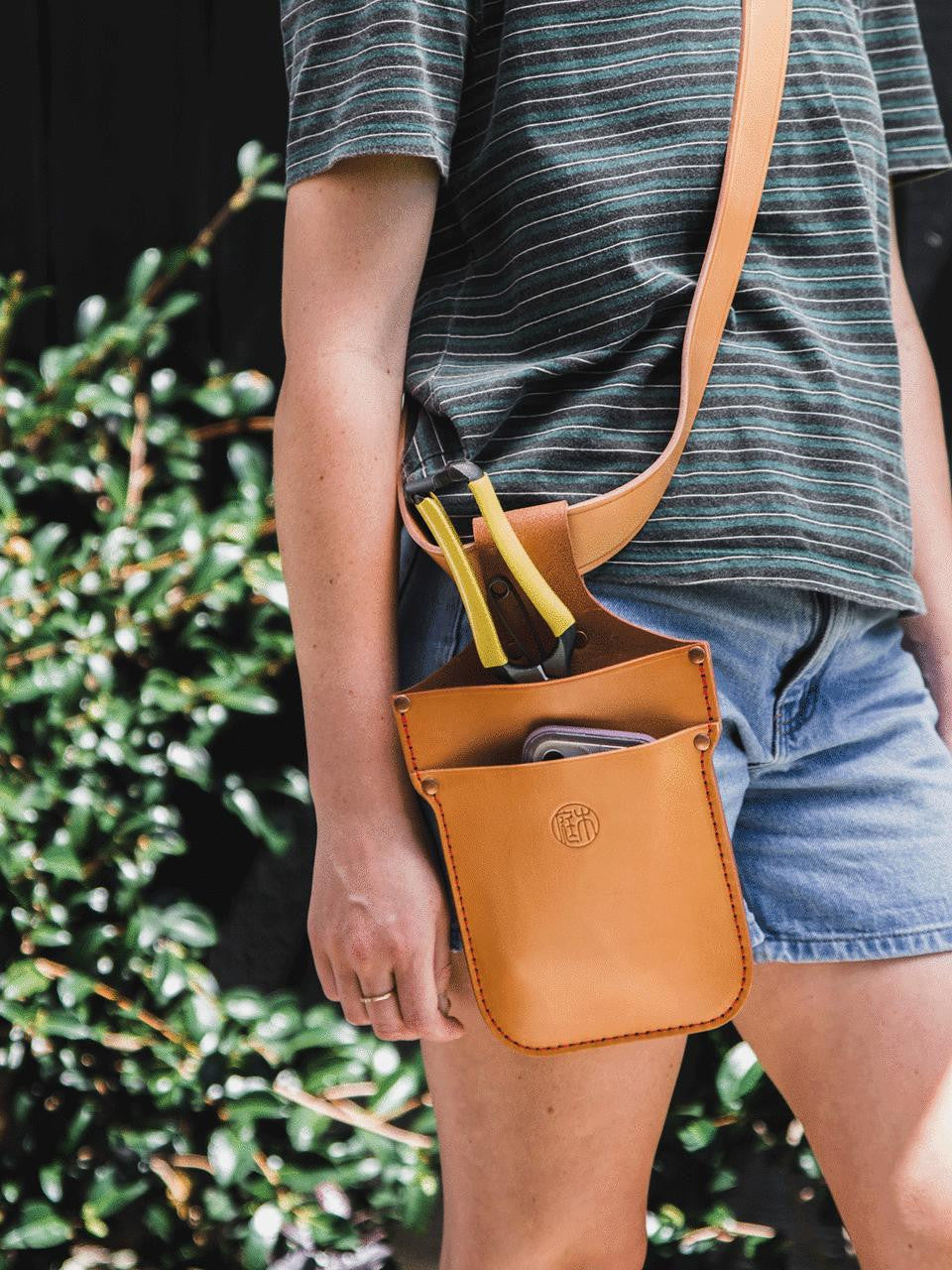 Niwaki tan leather belt with adjustable strap and metal buckle, versatile accessory for casual or formal outfits.