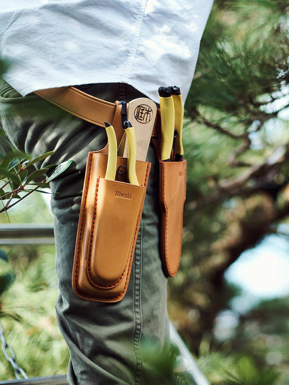 Niwaki double holster with leather straps and metal buckles, designed for secure tool storage and easy access.