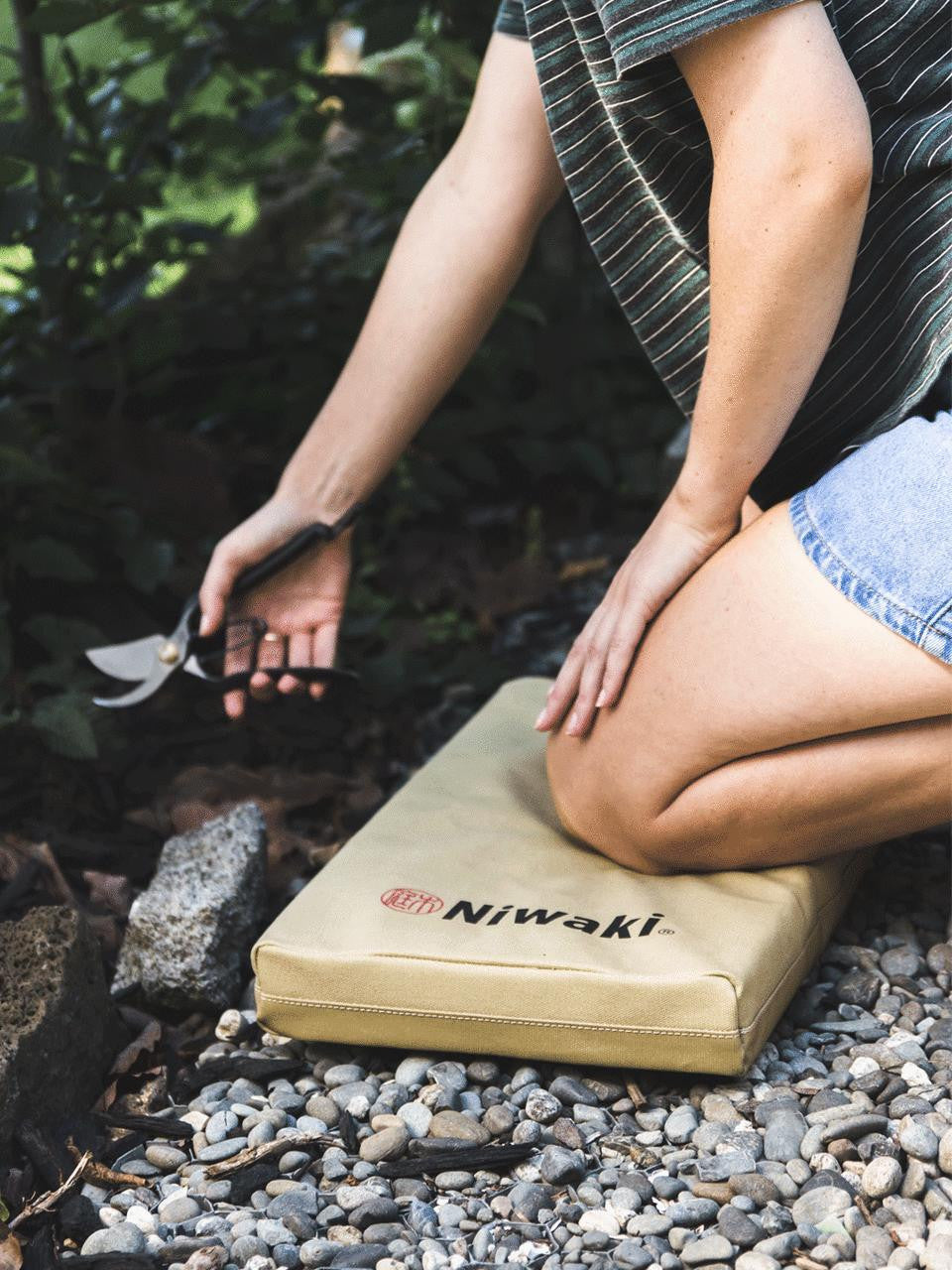 Niwaki kneeler with cushioned surface and sturdy frame, designed for gardening comfort and support.