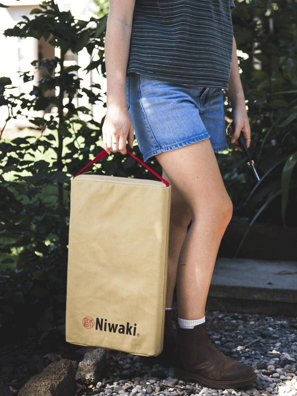Niwaki kneeler with padded cushion and wooden frame, ideal for gardening or outdoor work.