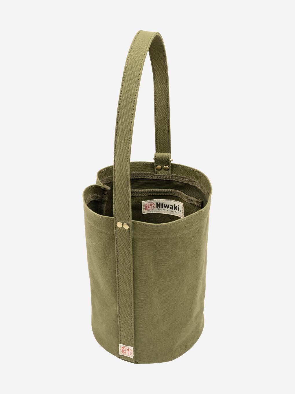 Green Mini Kantan Bag by Niwaki with compact, stylish design and adjustable strap, perfect for carrying small essentials.