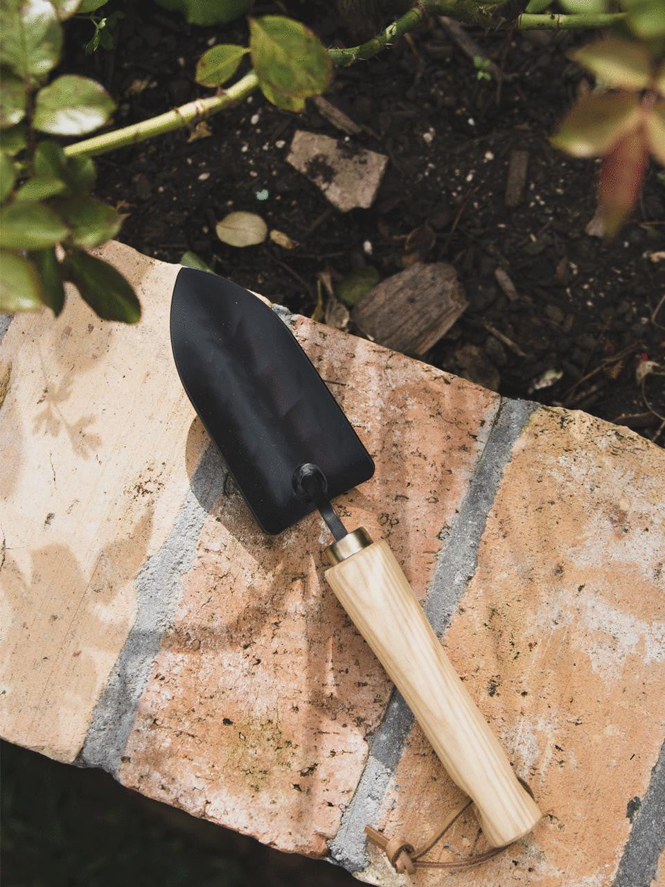 Niwaki Moku Trowel with wooden handle and metal blade, ideal for gardening and planting tasks.