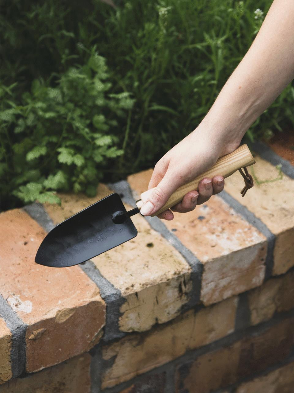 Niwaki Moku Trowel with wooden handle and metal blade, ideal for gardening and planting tasks.