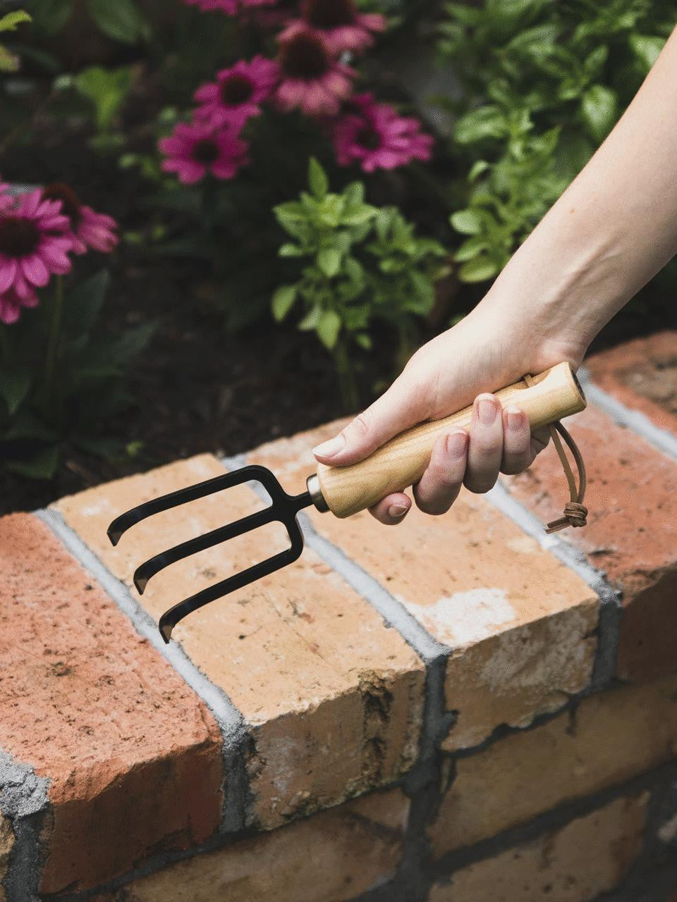 Niwaki Moku Cultivator with small ergonomic handle and metal tines for precise soil aeration and gardening tasks.
