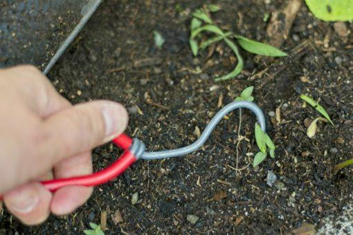 Wonder Weeder gardening tool with ergonomic handle and metal prongs for effortless weed removal in the garden.